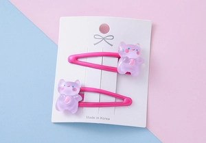 Close-up of pink metal BB clips with purple resin bear charms on a display card
