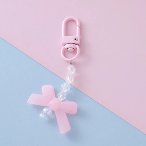 Detailed view of candy pink acrylic bow keychain with transparent beads and lobster clasp