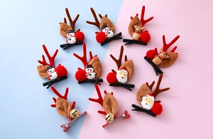 Detalle de pinzas para el pelo navideñas con astas de reno de felpa y motivos de muñecos de nieve
