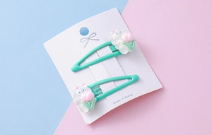 Close-up of cute white rabbit resin hair clips with mint green metal base and tulips