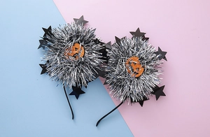 Detail view of Halloween headbands with silver brush balls and orange glitter pumpkin decor