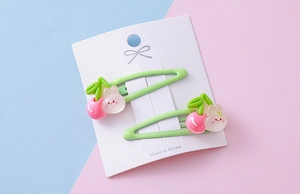 Close-up of strawberry rabbit hair clips with matte texture and cherry accents