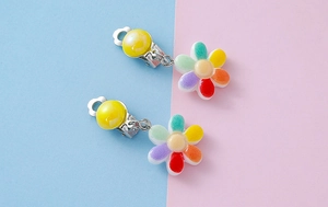 Close-up of rainbow resin sunflower clip-on earrings for kids without piercings