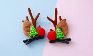 Detalle de pinzas para el cabello con astas de reno, árbol de Navidad y pompones rojos