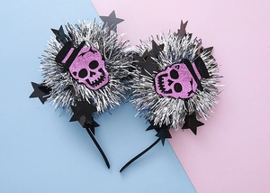 Detail of Halloween headband with purple glitter skull and silver tinsel puff ball accents
