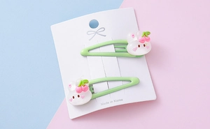 Close-up of cute white rabbit resin charms on light green metal BB hair clips