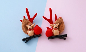 Detalle de pinzas para el pelo de cuernos de reno navideños con muñeco de peluche rojo