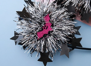 Detailed close-up of a pink glittery bat and silver tinsel headband for Halloween parties