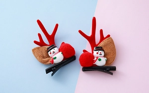 Detalle de las pinzas para el pelo con astas de reno, muñecos de nieve y pompones
