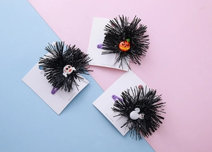 Detail of Halloween hair clips featuring pumpkin, skull, and cat motifs with pom-poms