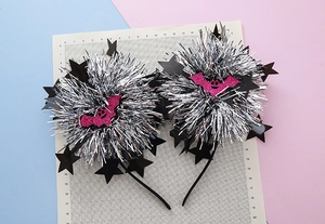 Detail of Halloween headband with silver pom-poms, black stars and pink glitter bats