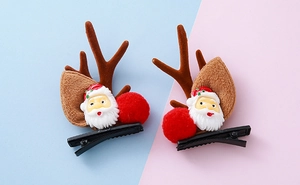Detalle de pinzas para el pelo con astas de reno de Navidad y pompones rojos