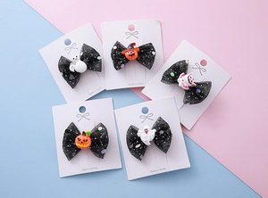 Détail de cinq barrettes d'Halloween avec nœuds en résille pailletée et motifs fantômes