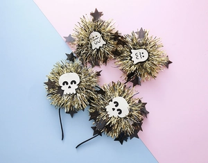 Close-up of Halloween headbands with golden tinsel balls, white skulls and ghosts