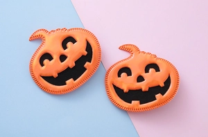 Détail de deux pinces à cheveux citrouille orange avec coutures noires pour Halloween