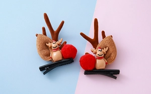 Detalle de pinzas para el cabello con astas de reno navideñas y muñecos de peluche