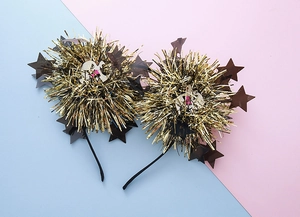 Detail of gold tinsel pom pom headband with translucent star sequins for party