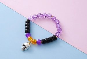 Detailaufnahme des Halloween-Armbands mit lila Kristallen und silbernem Totenkopf-Anhänger