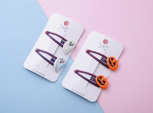 Détail de barrettes d'Halloween avec fantômes pailletés et citrouilles sur présentoirs