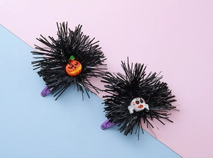 Detail of Halloween hair clips with glitter bats and pumpkins on purple clips