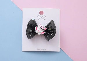 Détail d'un nœud d'Halloween avec tulle à pois noirs et breloque chauve-souris mignonne