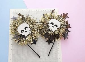 Detail of Halloween headband with gold black PET fringe balls and white skull charms