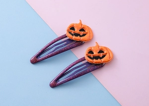 Détail de barrettes d'Halloween avec paillettes violettes et citrouilles en 3D