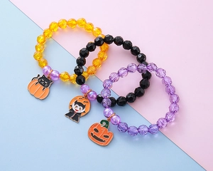 Detailed view of Halloween beaded bracelets with enamel pumpkin and ghost charms
