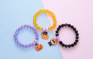 Detailed macro view of colorful Halloween beaded bracelets with cute pumpkin and cat charms