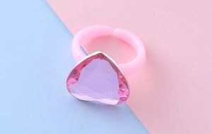 Dettaglio dell'anello con gemma rosa a cuore e fascia regolabile per bambini