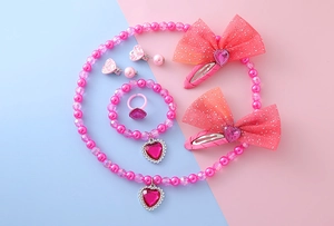 Pink heart jewelry set for kids including beaded necklace, bracelet and glitter clips