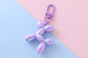 Dettaglio del portachiavi a forma di cane palloncino viola iridescente con gancio