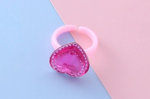 Dettaglio anello a cuore rosa per bambine con bordo ondulato argento e fascia aperta