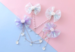 Detailed macro view of mermaid bow hair clips with pearl tassels and seashell charms