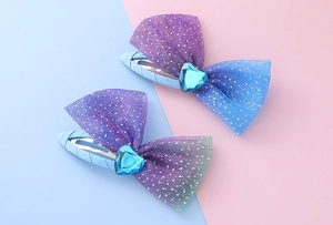 Detail of mesh heart hair clips with purple and blue glitter tulle bows in 2-pack