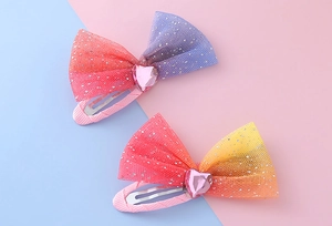 Detailed view of two gradient mesh bow clips with heart-shaped faux gemstones for girls