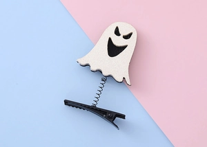 Detail of a white glitter ghost hair clip with a spring on a pastel pink and blue background