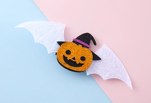 Detalle de horquilla de calabaza brillante con sombrero de bruja y alas para Halloween