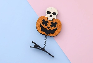 Detail of Halloween hair clip with a sequined orange pumpkin and small white skull