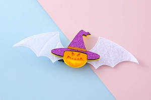 Detalle de pinza para el pelo de Halloween con calabaza, sombrero de bruja y brillo morado