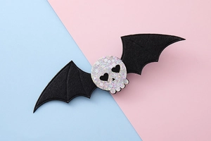 Detalle de pinza de pelo de Halloween con calavera brillante y alas de murciélago de fieltro