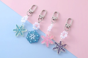 Detail view of snowflake keychains with glitter resin charms and iridescent beads decoration