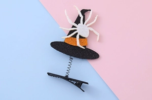 Detail of Halloween witch hat hair clip with orange glitter band and white spider on spring