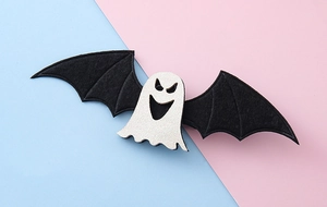 Detalle de pinza para el pelo con fantasma blanco brillante y alas de murciélago negras