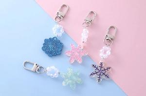 Detail of colorful snowflake charms with glitter finish and metallic lobster clasps