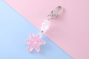 Close-up of pink snowflake pendant with laser texture beads and silver lobster clasp