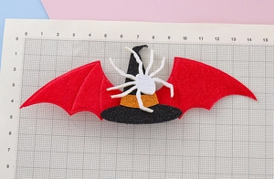 Detalle de la pinza de pelo de Halloween con sombrero de bruja y alas de murciélago