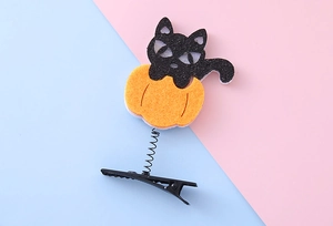 Detail of Halloween hair clip with a black cat on a pumpkin and spring mounted metal clip