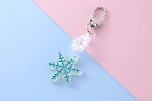 Close-up of snowflake keychain with blue resin charm and iridescent crystal beads