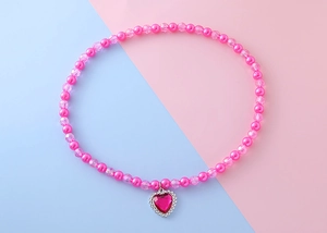 Détail de perles roses et pendentif cœur avec strass pour collier de fille